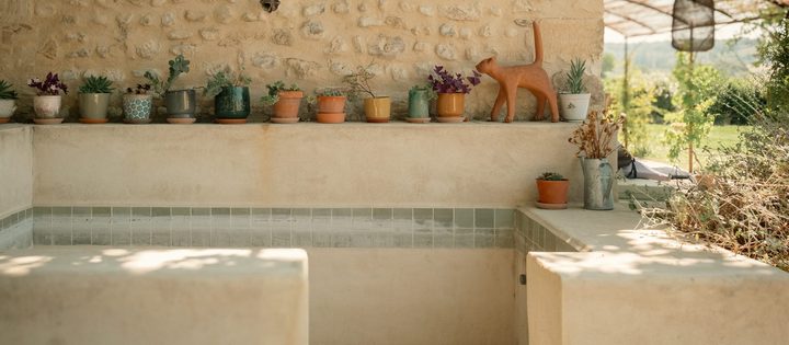 Le bassin et la terrasse couverte, le long du mur en pierre